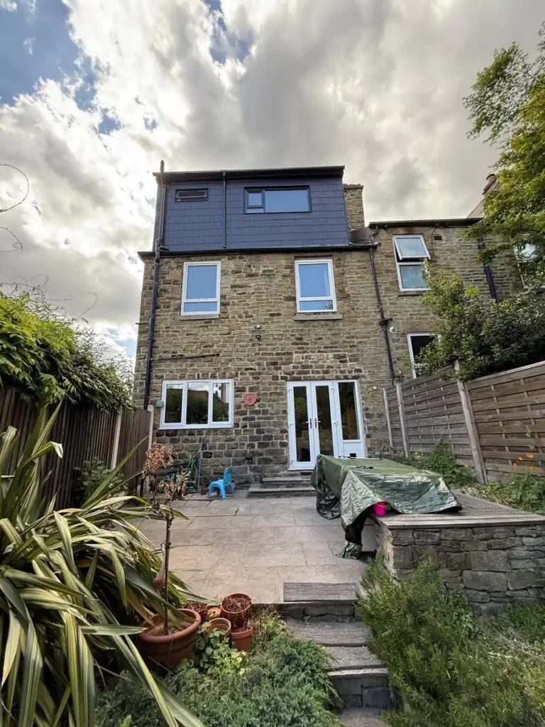 Completed dormer loft conversion on the rear of a stone terraced house in Sheffield, with new slate cladding and windows