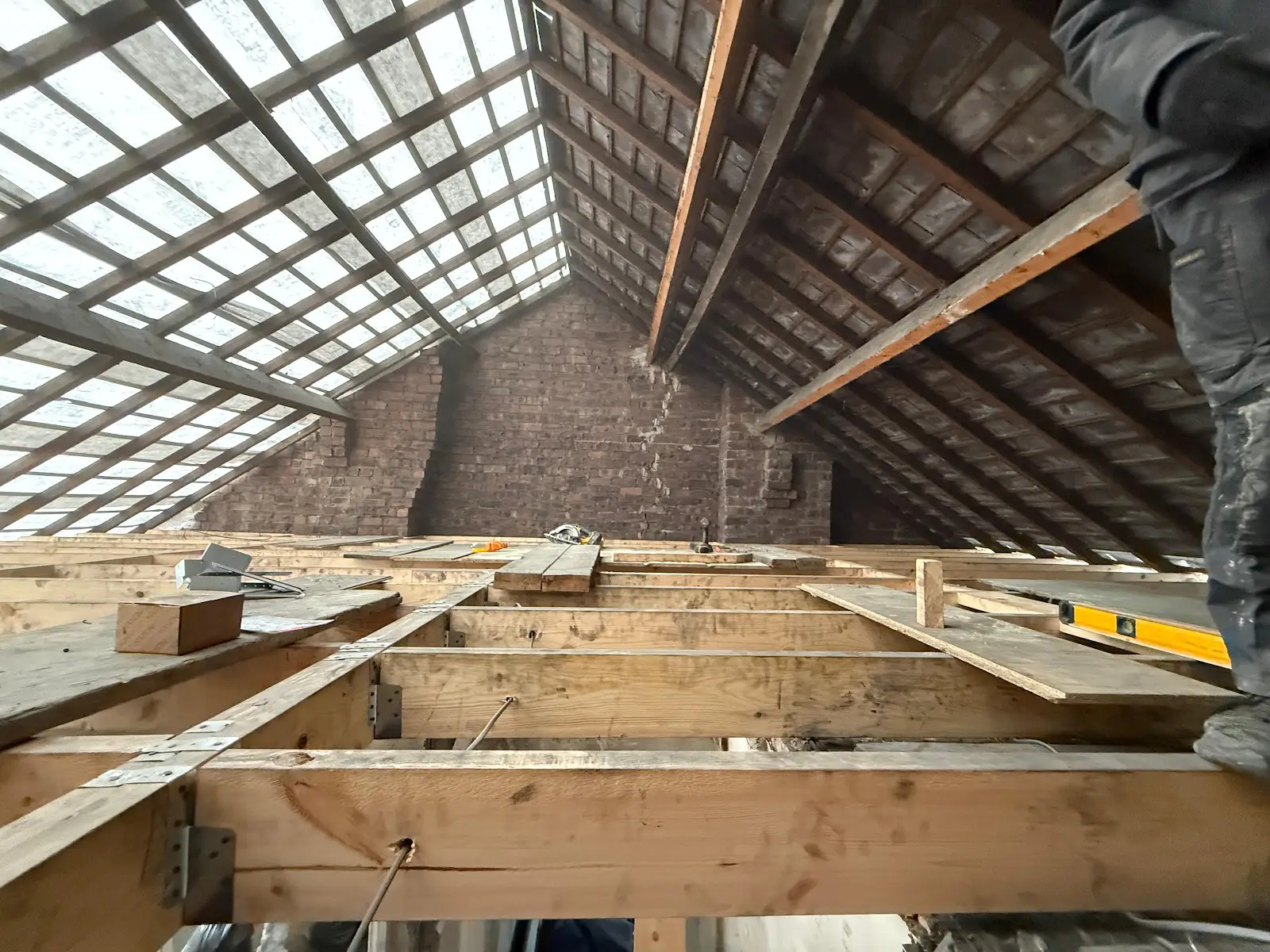 Exposed roof rafters and timber floor framing inside the loft