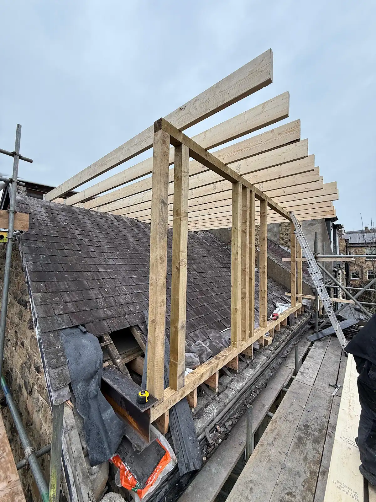 Timber dormer wall studs and roof joists above the existing slate roof